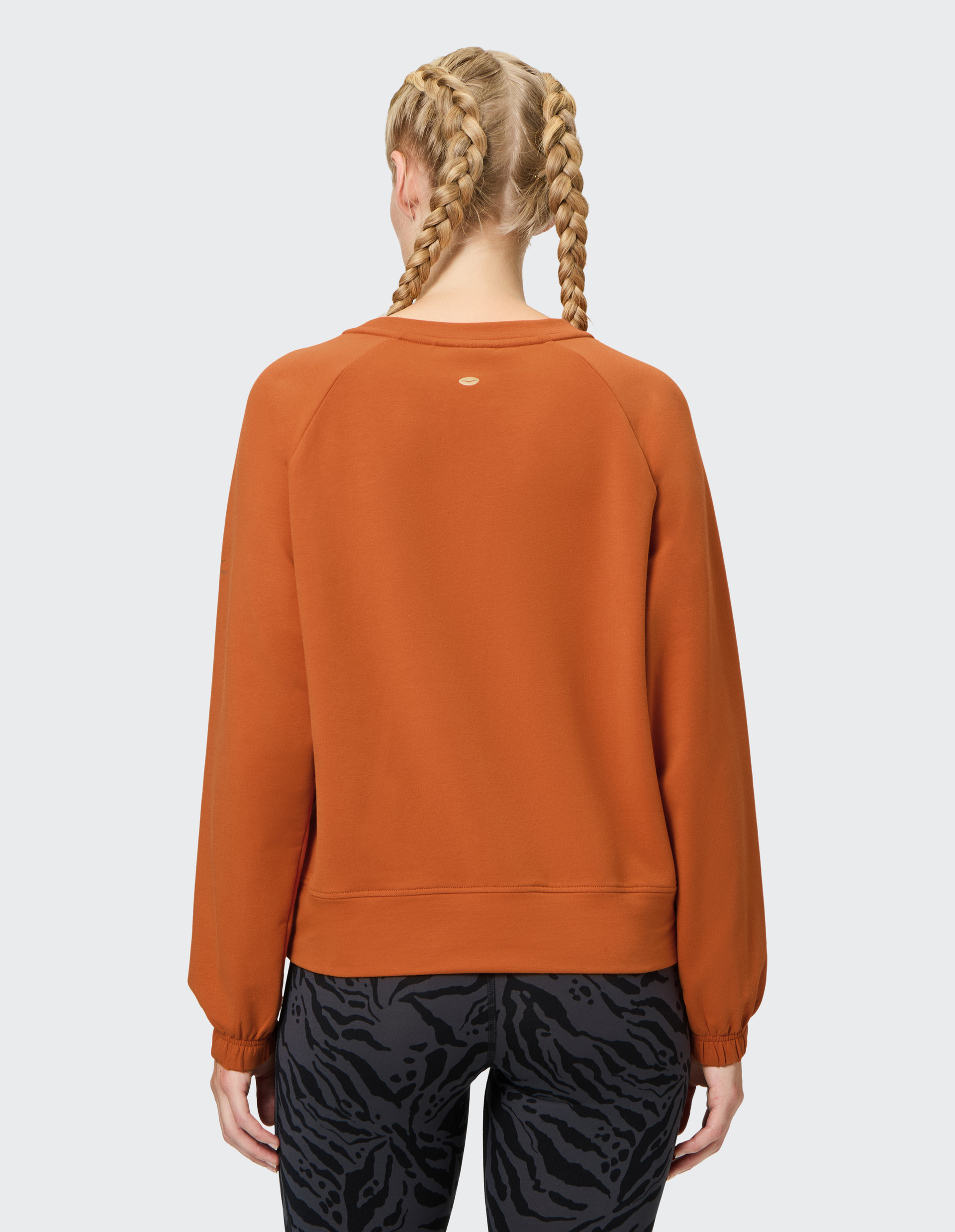 Orangefarbener Pullover mit Rundhalsausschnitt und Raglanärmeln, auf der Brust steht in gelber Schrift "California Los Angeles".