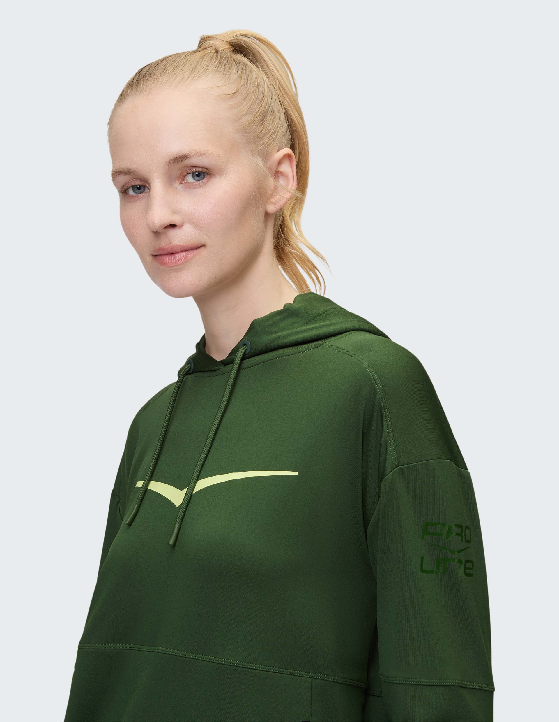 Dunkelgrüner Kapuzenpullover mit hellgrünem Chevron-Design auf der Brust, Kordelzug an der Kapuze und dezenten Bündchen.