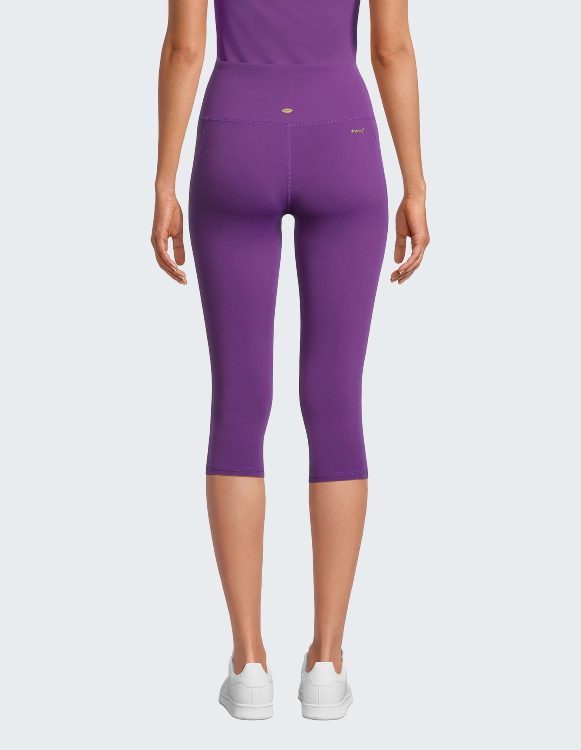 Ein Paar lila Capri-Leggings mit einem kleinen goldenen Logo am Bund.