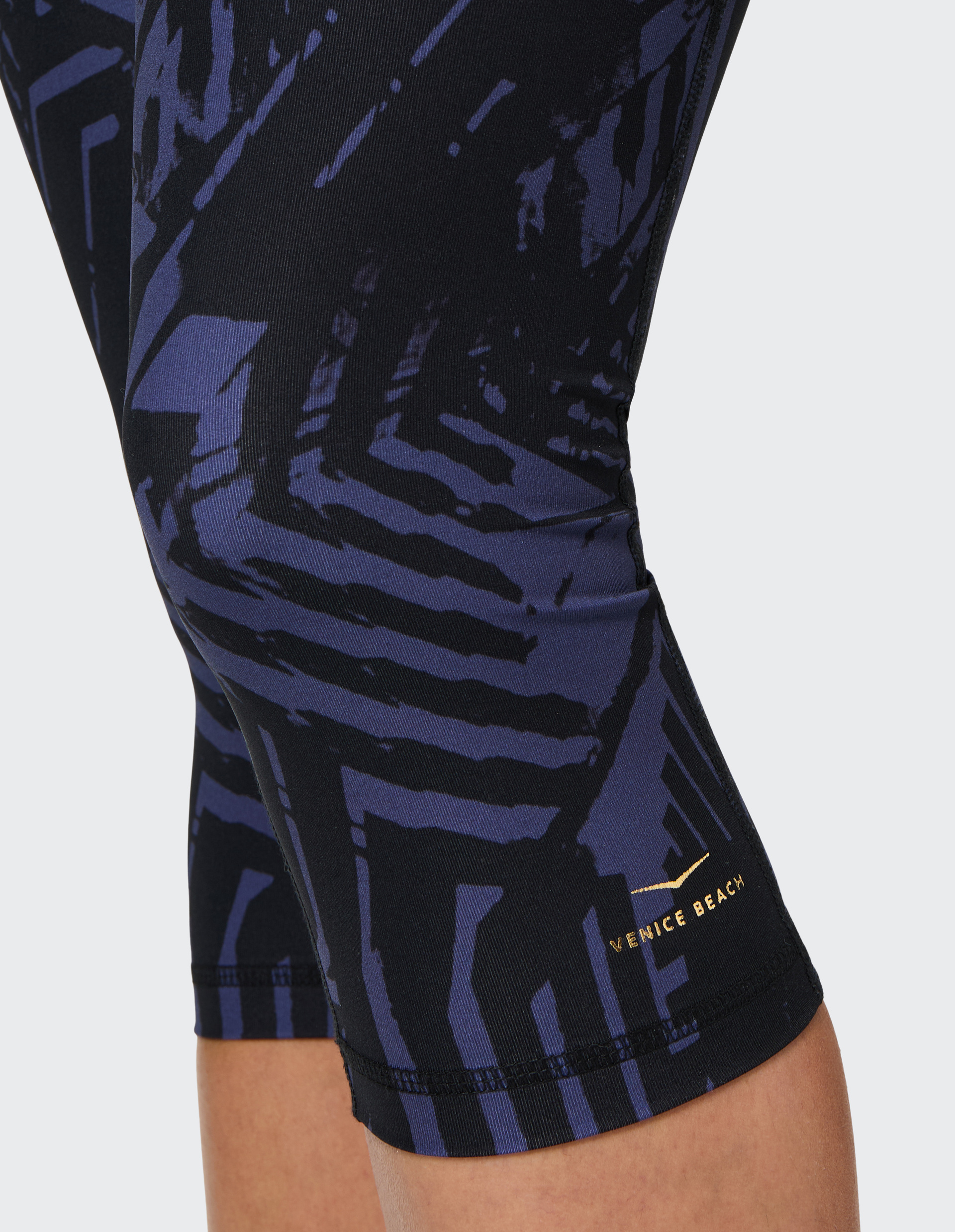 Dunkle Leggings mit geometrischem, blau-schwarzem Muster und hellem Bund, der ein modernes, sportliches Design betont.
