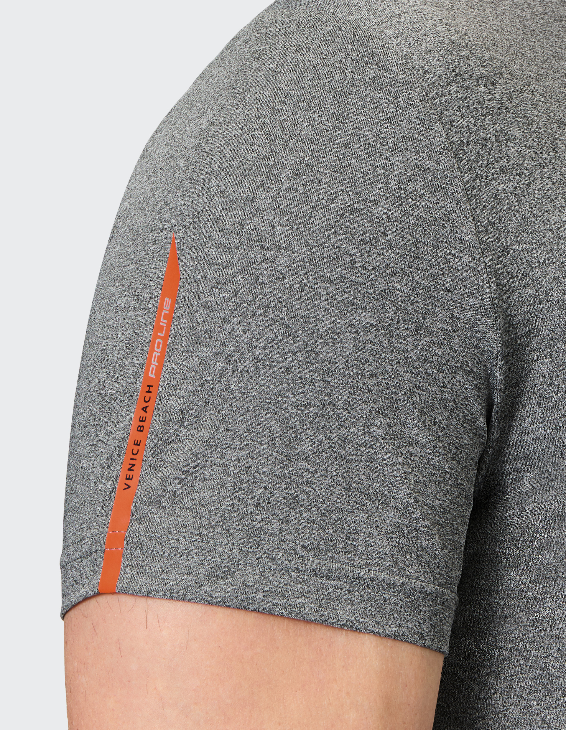Graues Shirt-Ärmel mit orangefarbenem, vertikalem Logoaufdruck "Venice Beach Pro Line" auf dem linken Oberarm einer Person.