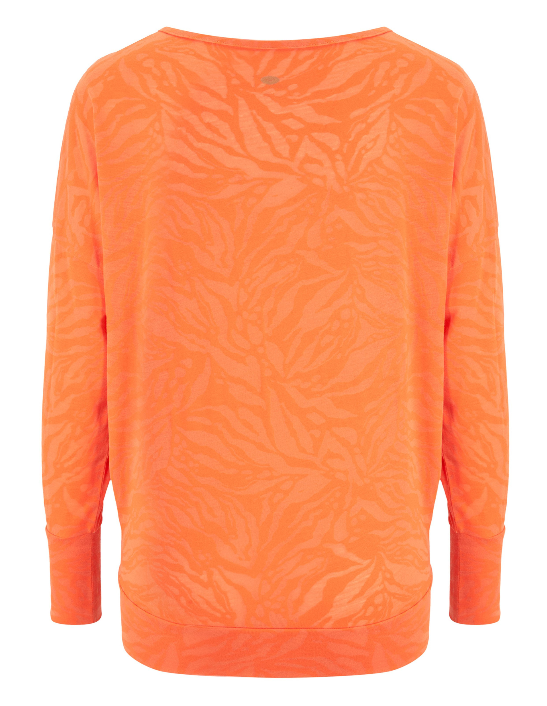 Ein orangefarbenes Oberteil mit langen Ärmeln und einem dezenten, abstrakten Muster in ähnlichen Tönen, das eine lebhafte Textur erzeugt.