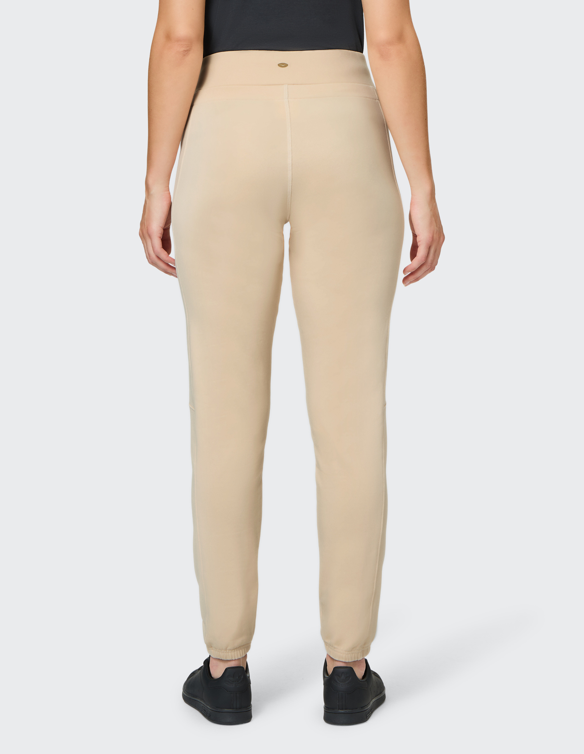 Beige Jogginghose mit einem elastischen Bund und Kordelzug, enganliegendem Schnitt und seitlichen Taschen, ideal für sportliche Aktivitäten.