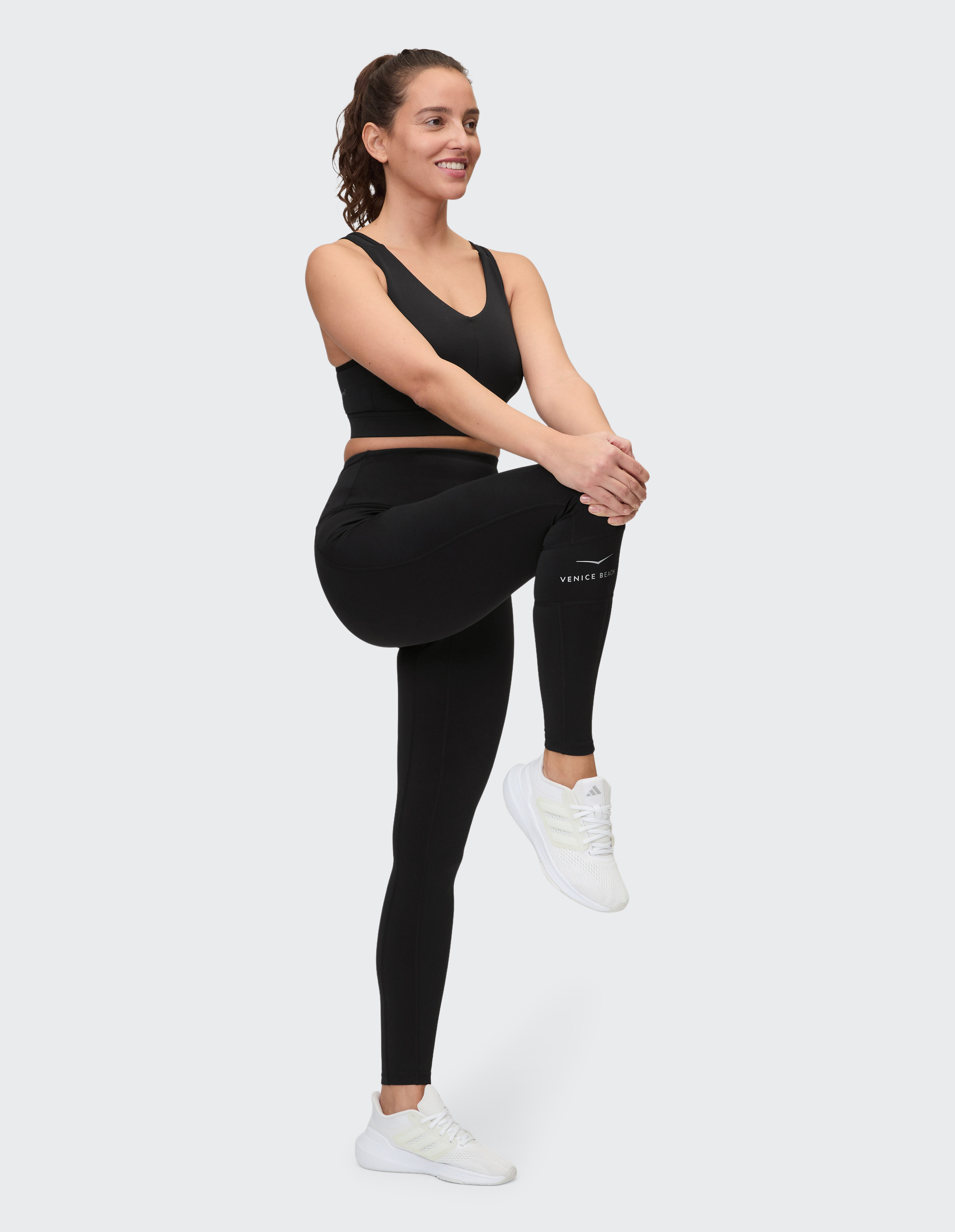 Schwarzes, ärmelloses Top mit V-Ausschnitt und kleinem Venice Beach Logo am unteren Saum, schlichtes und sportliches Design.