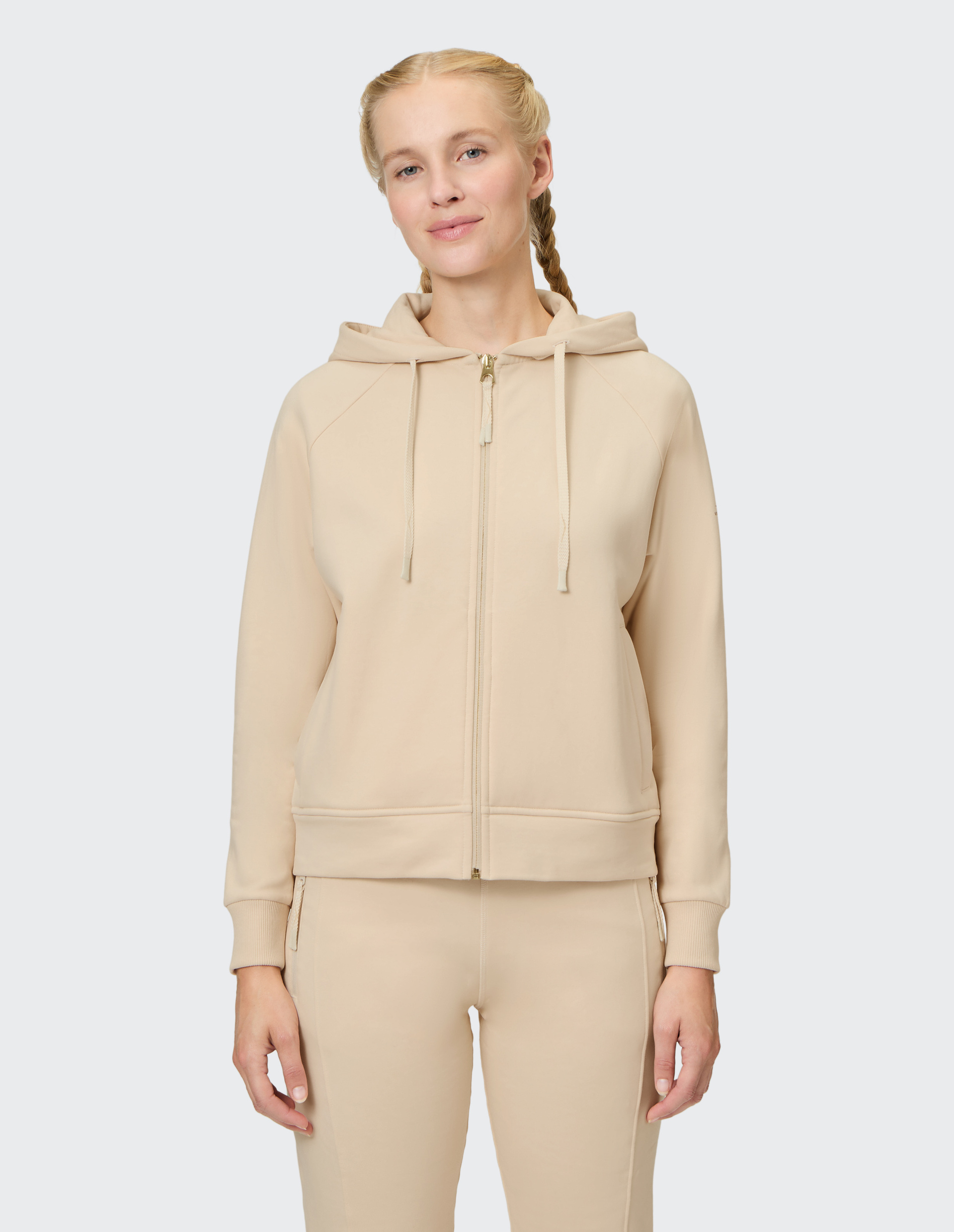 Beiger Kapuzenpullover mit Reißverschluss und Kordelzug, langen Ärmeln, Rippenbündchen und zwei Seitentaschen.