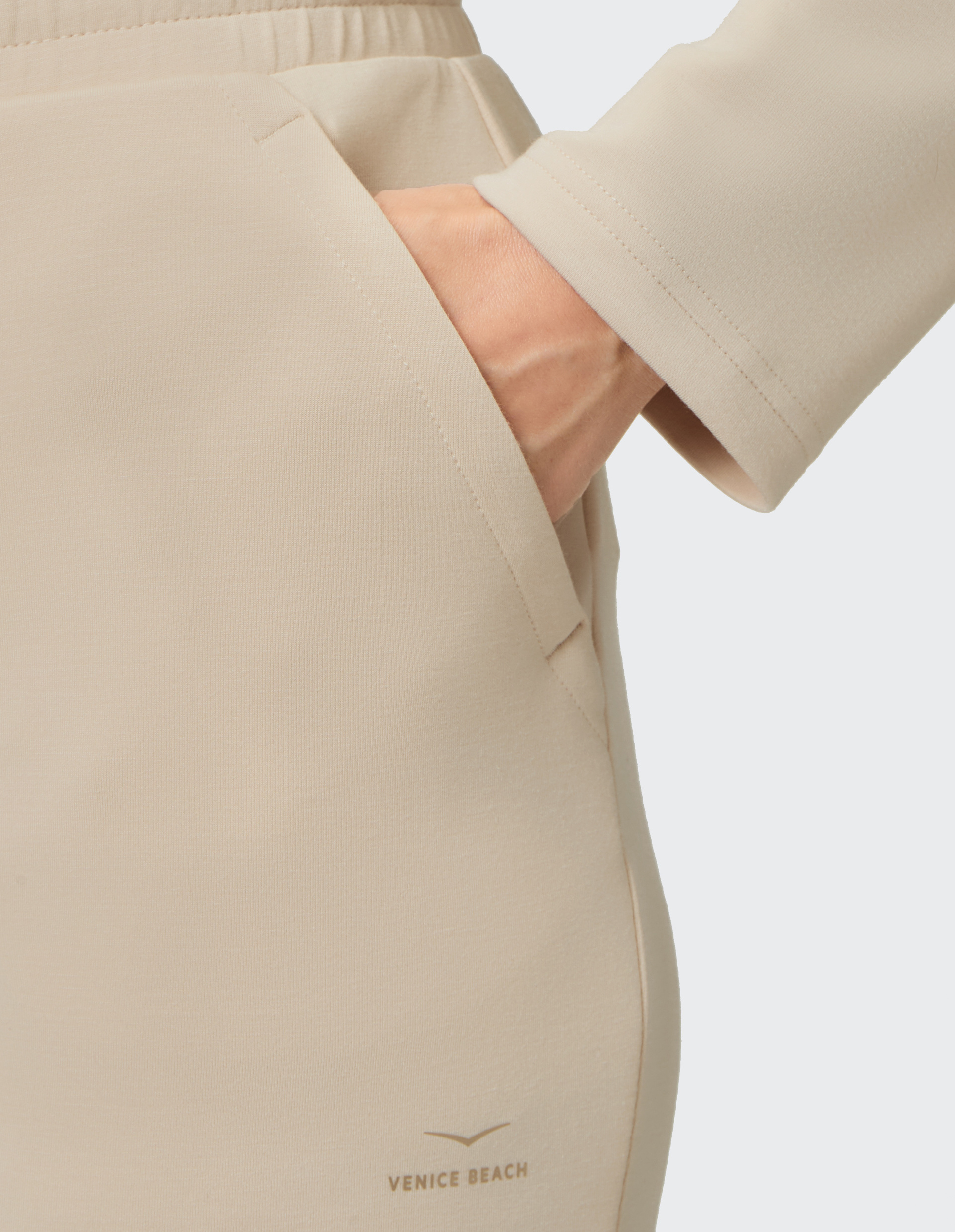 Beige Jogginghose mit elastischem Bund, Tunnelzug und seitlichen Taschen, schlichtes Design für bequemen Alltagskomfort.