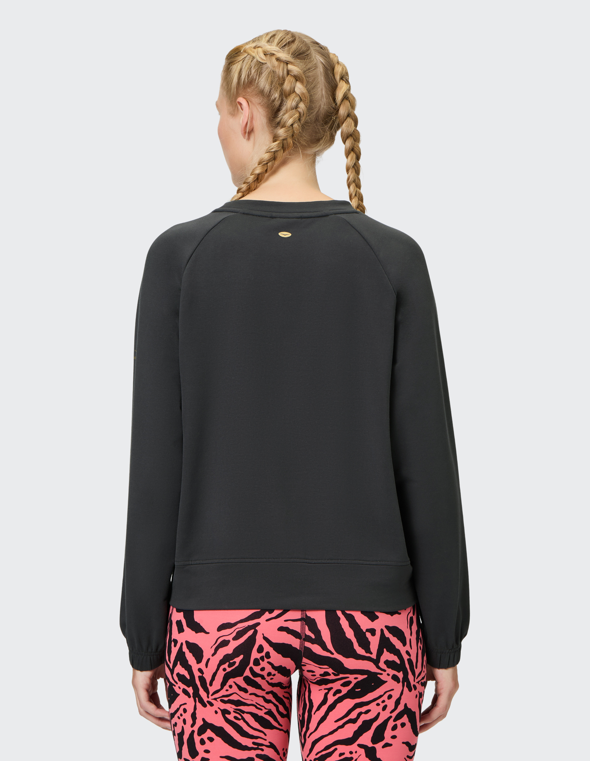 Schwarzer Pullover mit Raglanärmeln und elastischen Bündchen, minimalistisches Design mit dezentem Streifendetail an der Vorderseite.