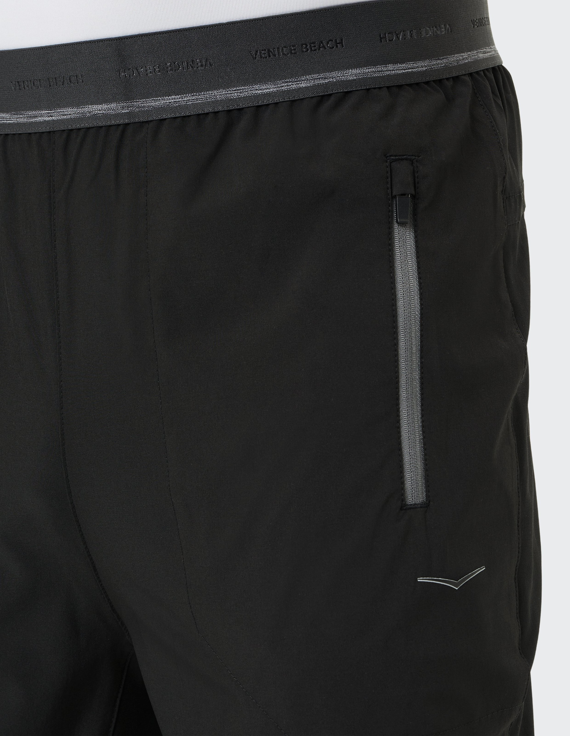 Schwarze Sportshorts mit elastischem Bund und seitlichem Reißverschluss; Stoffetikett wiederholt den Schriftzug "Venice Beach".