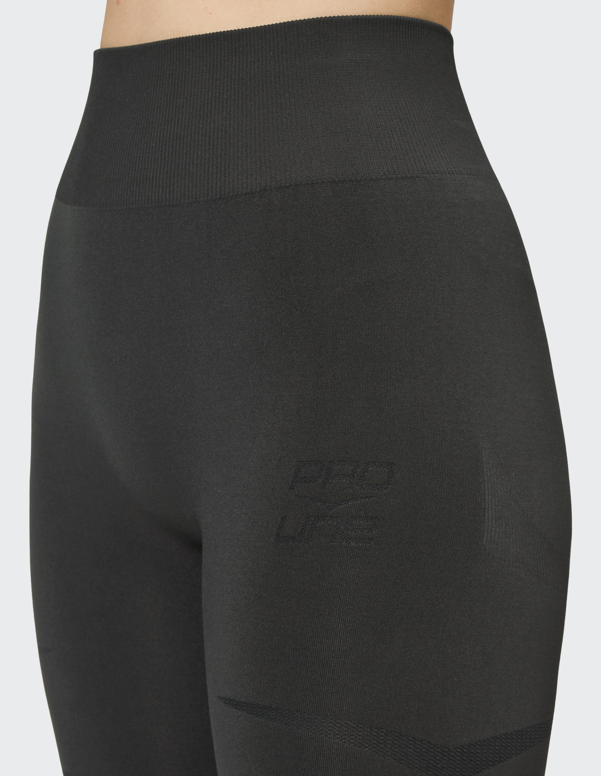 Schwarze, nahtlose Leggings mit hohem Taillenbund und subtiler Textur; Aufschrift "PRO LIFE" in dunklem Reliefmuster.