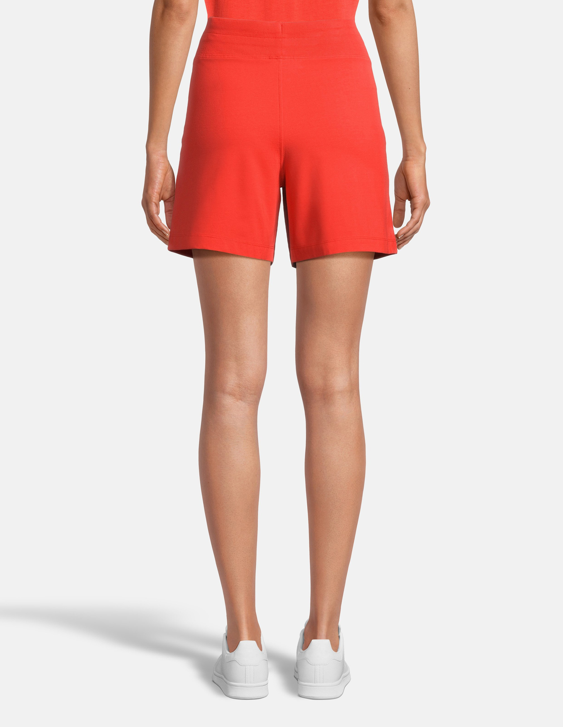 Leuchtend orangefarbene Shorts mit elastischem Bund, Kordelzug und zwei Seitentaschen, aus weichem, leichtem Stoff.