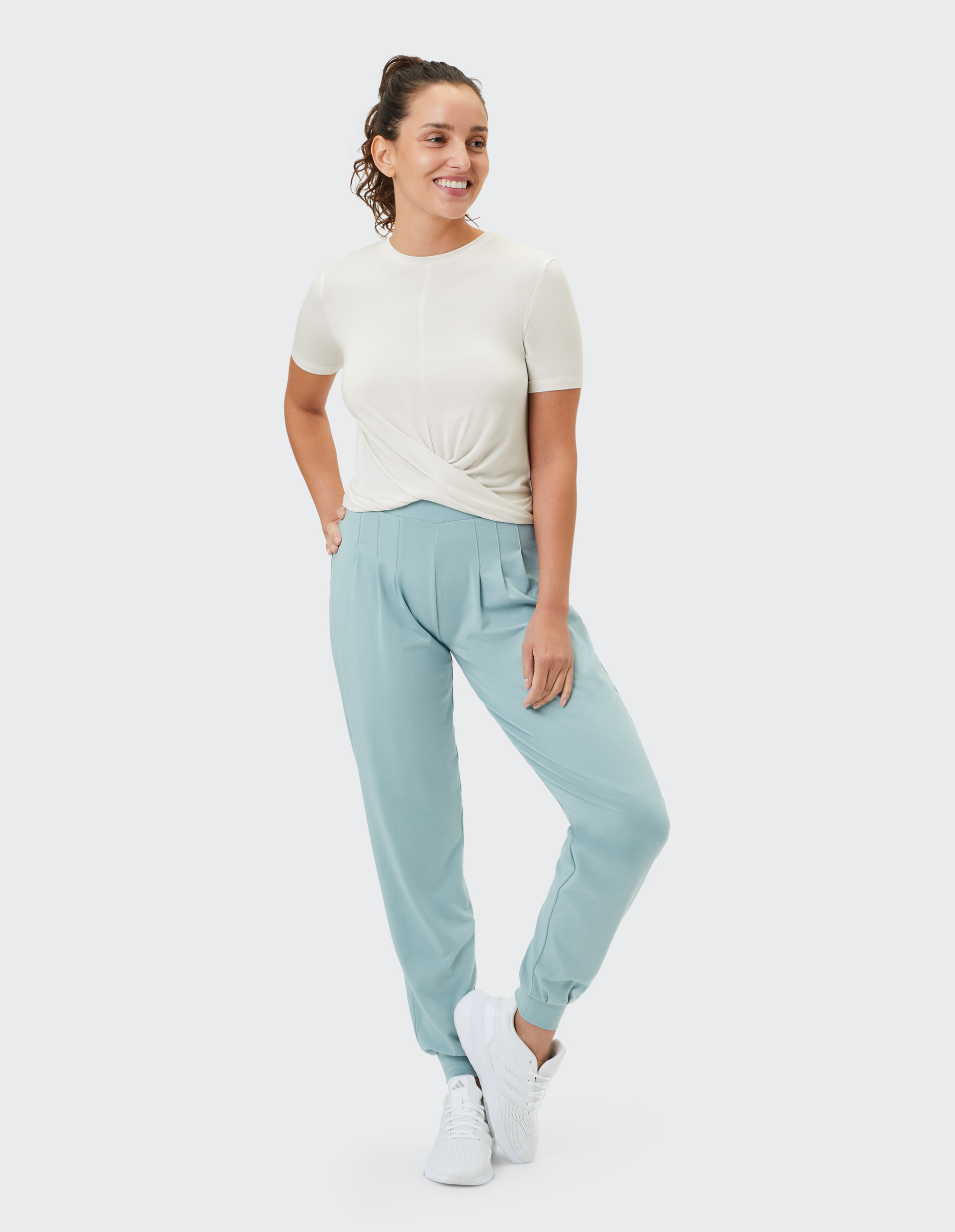Ein weißes T-Shirt mit kurzen Ärmeln und einem asymmetrischen Knoten-Detail vorne, das einen modernen, stilvollen Look verleiht.
