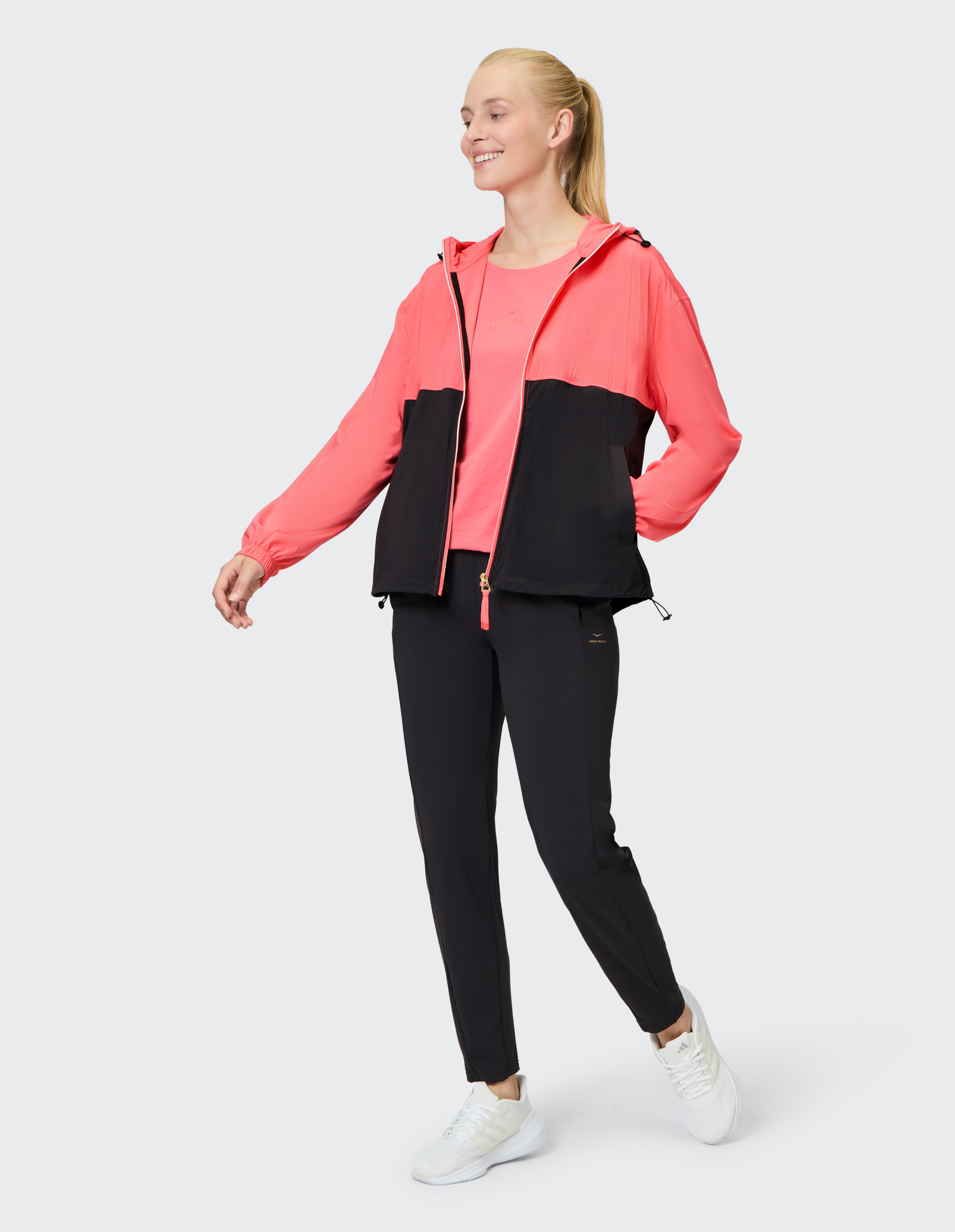 Eine zweifarbige Jacke mit Kapuze, oben korallenrot und unten schwarz, vorderem Reißverschluss und elastischen Ärmelbündchen.