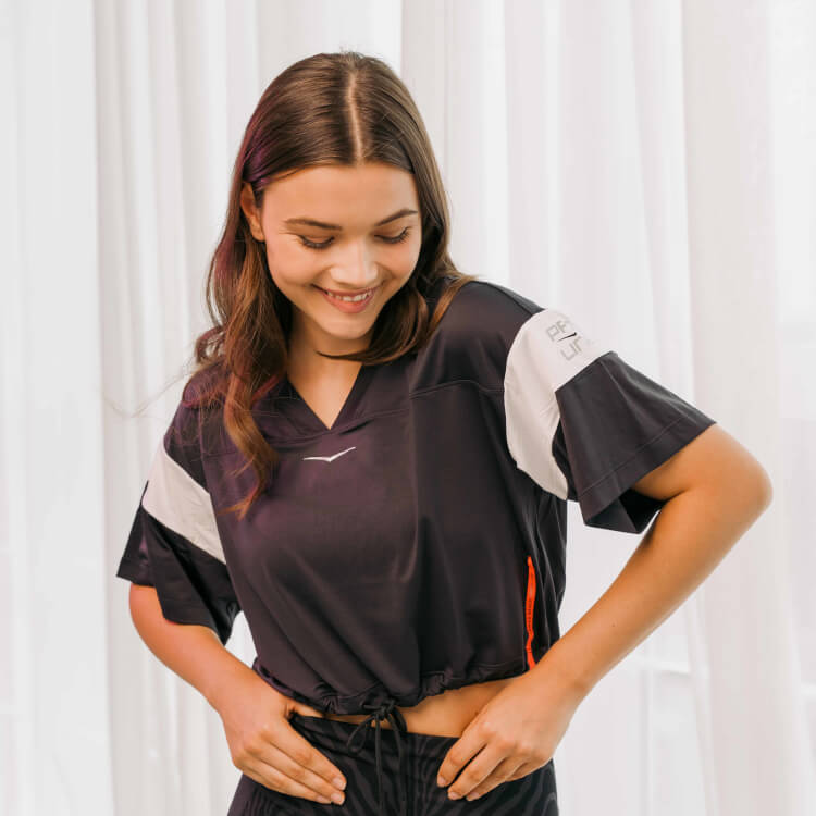 Frau mit braunen Harren und Cropped Shirt in den Farben Schwarz und Weiß.