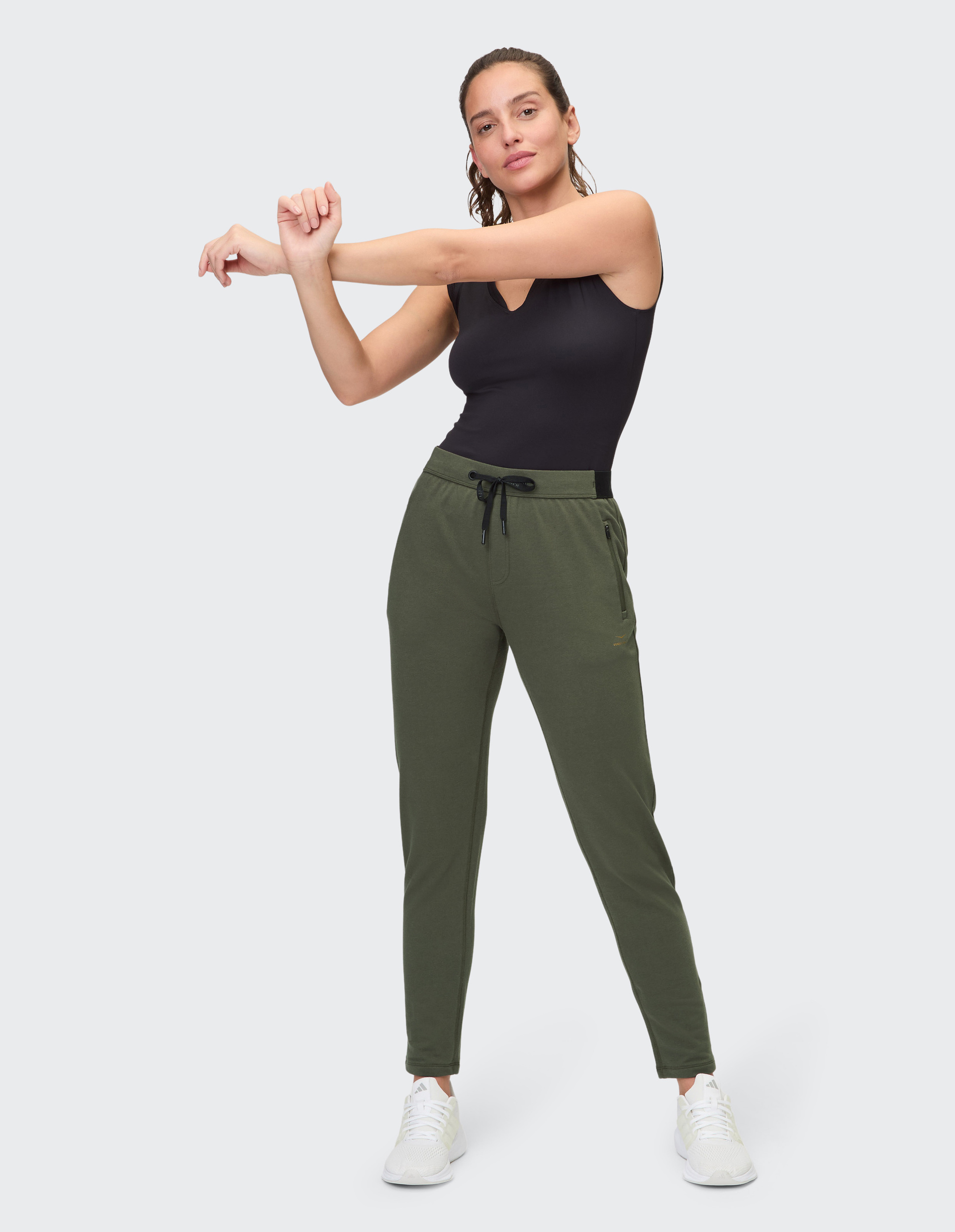 Dunkelgrüne Jogginghose mit Kordelzug am elastischen Bund, schmalem Bein und dezenter Logostickerei an der Seite.