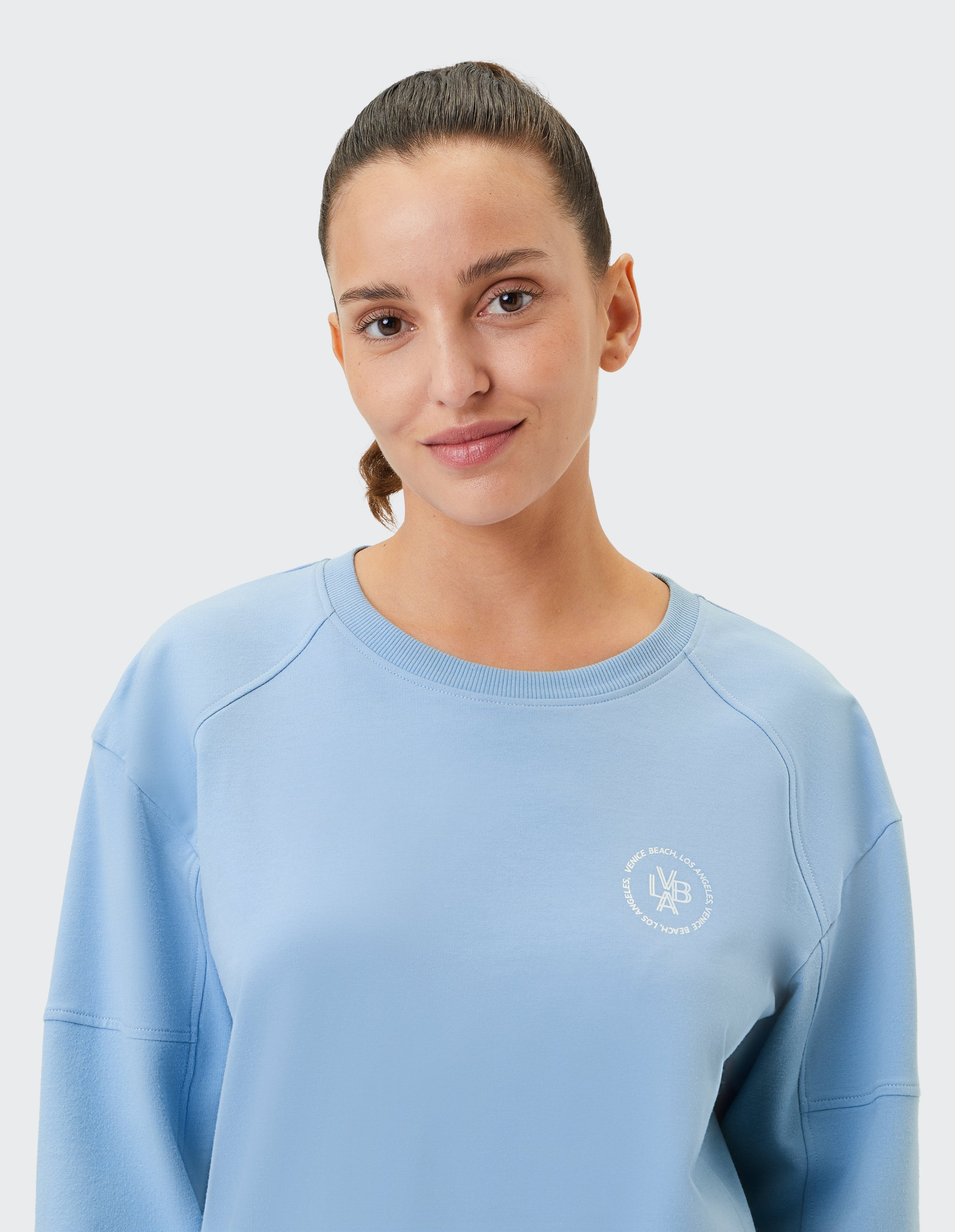 Hellblauer Pullover mit Rundhalsausschnitt, langen Ärmeln und weißem "Venice Beach"-Logo auf der linken Brust.