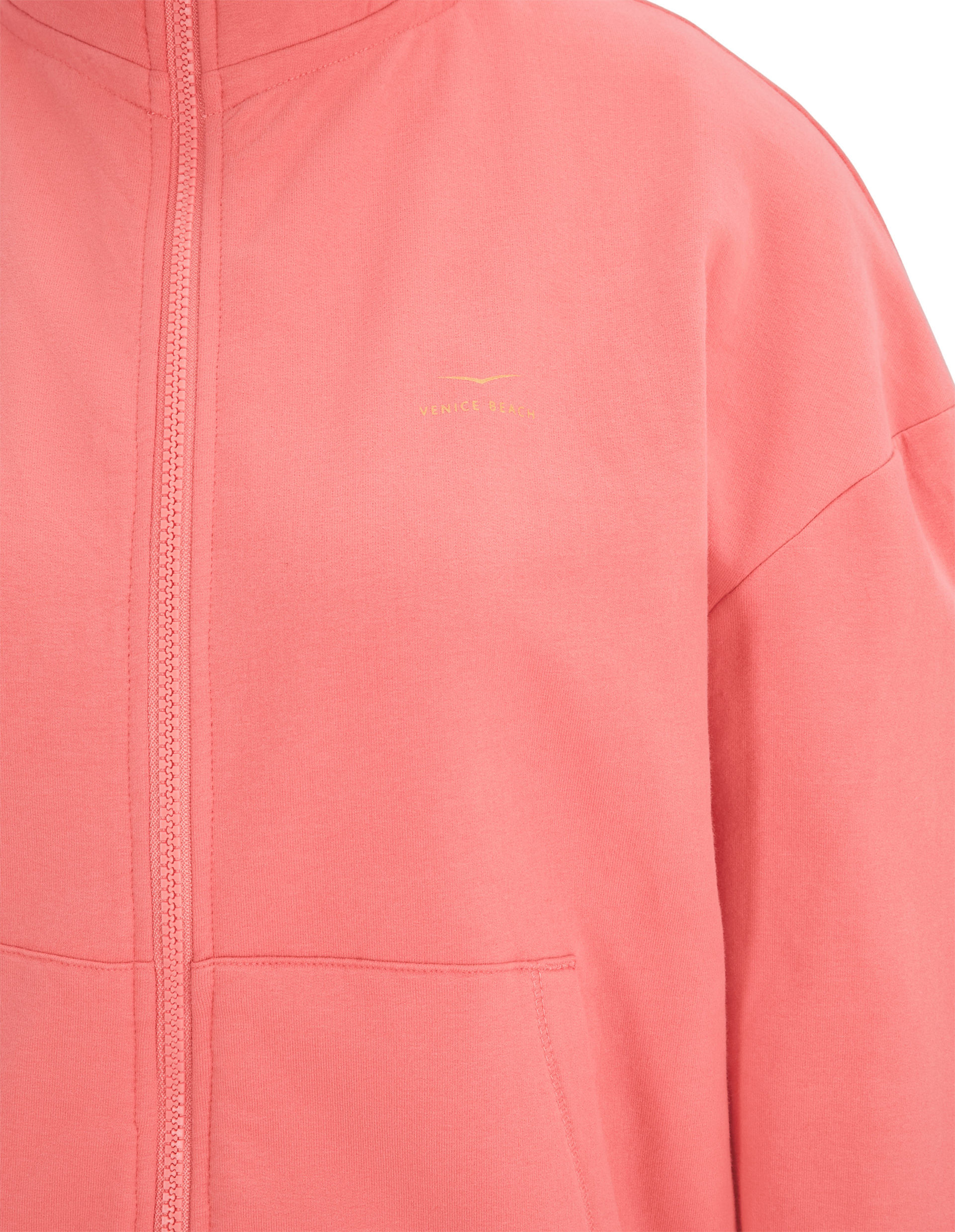 Nahaufnahme eines korallenroten Hoodies mit Reißverschluss und kleinem Venice Beach-Logo auf der Brust.