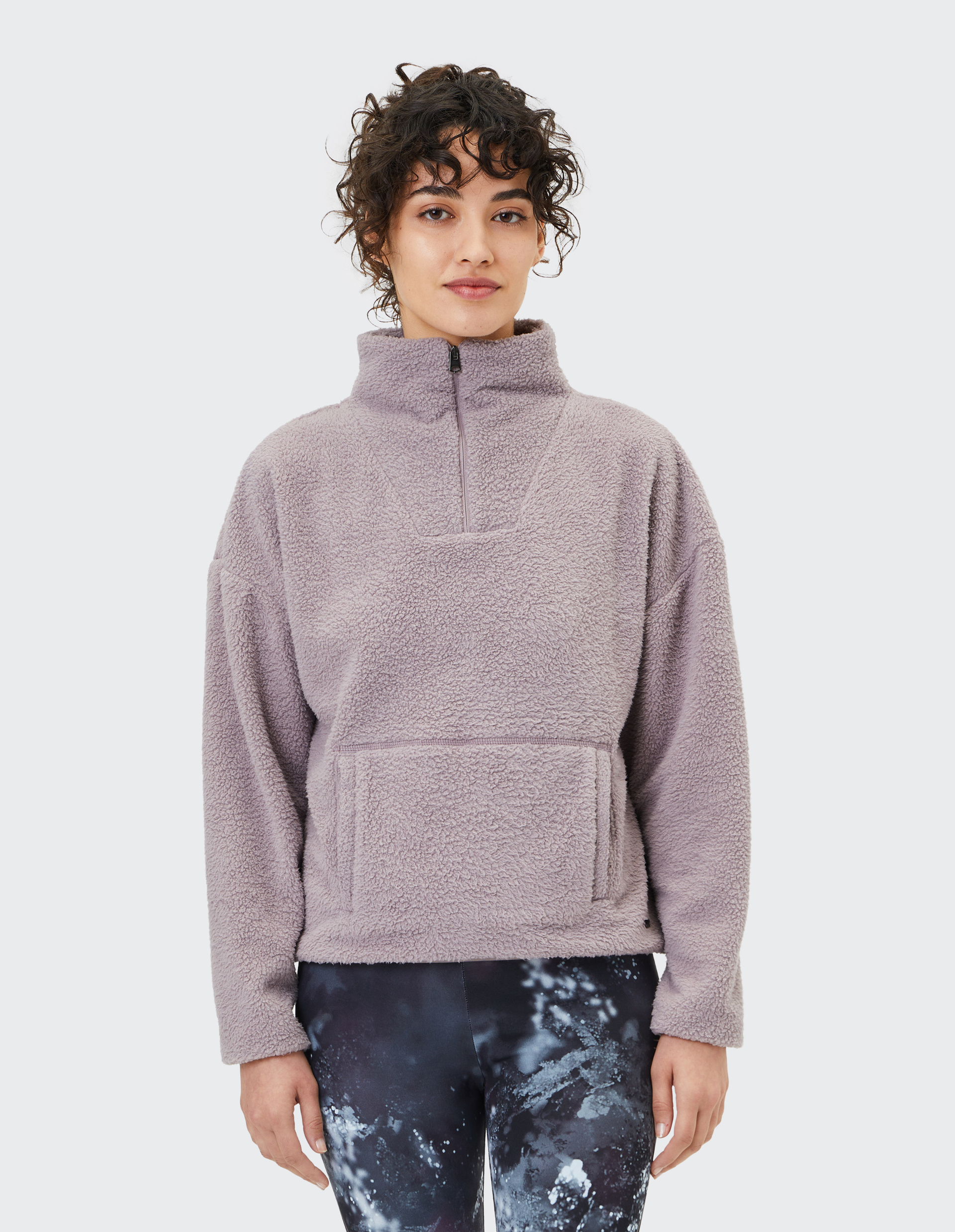 Flauschiger, hellgrauer Fleecepullover mit halbem Reißverschluss und Kängurutasche, geeignet für gemütliche und warme Anlässe.