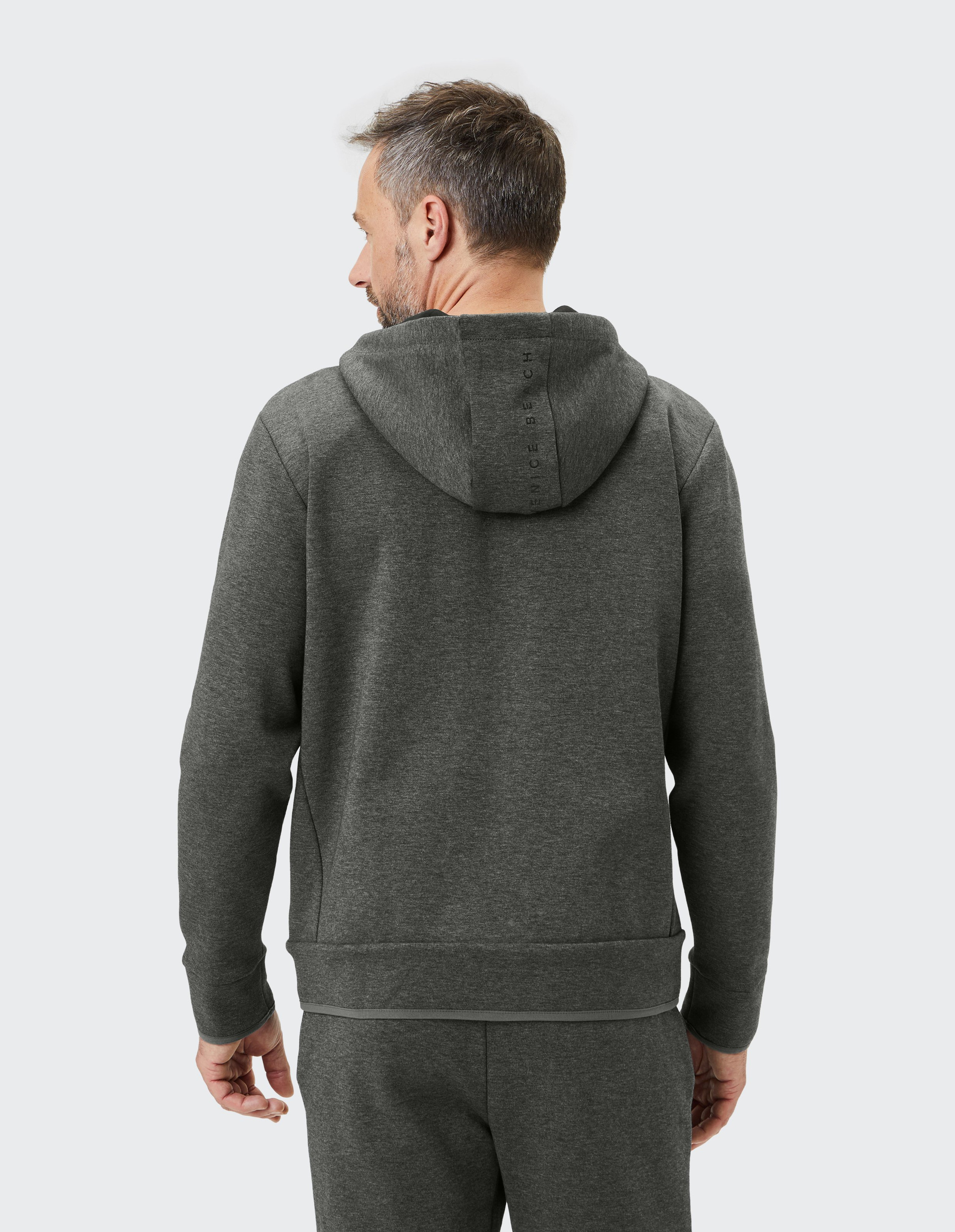 Dunkelgrauer Kapuzenpullover mit Reißverschluss, zwei Bändern an der Kapuze und dezentem Logo auf der linken Brustseite.