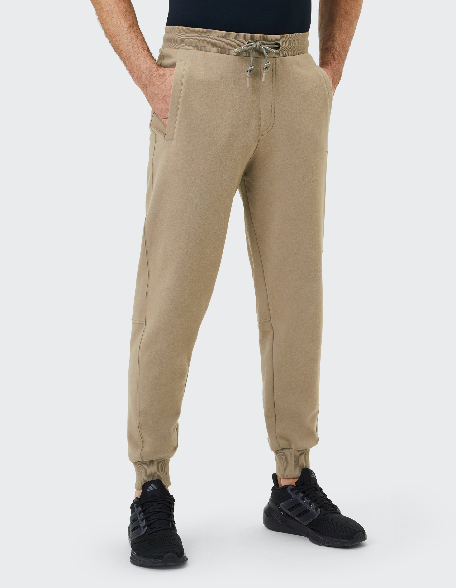 Beige Jogginghose mit elastischem Bund, Kordelzug und zwei seitlichen Taschen, gerippten Bündchen an den Beinabschlüssen.