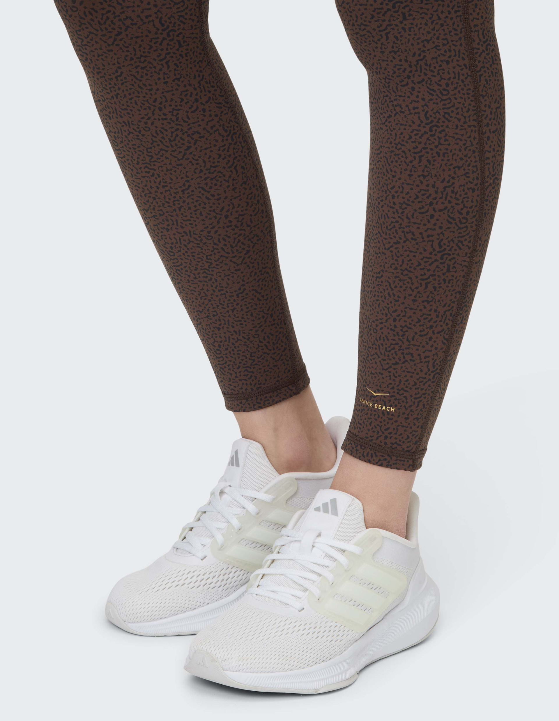 Braune Leggings mit feinem Punktmuster, elastischem Bund und engem Schnitt, ideal für Freizeit oder Sportaktivitäten geeignet.